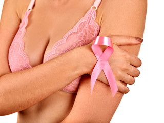 Pink badge on woman hand to support breast cancer cause.