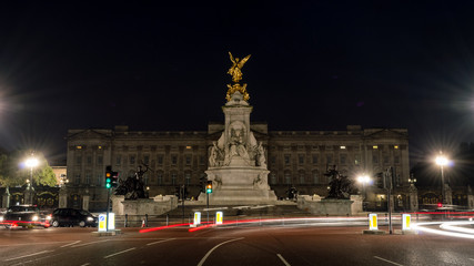 Statues in front of Buckingham Palace by night