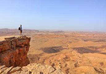 Foto op Plexiglas Magic desert landscape / View of Negev stone desert.Traveler on a cliff in the  National geological park HaMakhtesh HaGadol,Large Crater - geological erosion land form, Israel  © Alexey Protasov