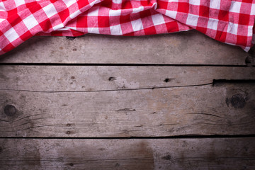 Red  checkered kitchen towel  on vintage  wooden background.