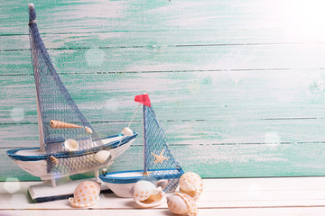 Decorative sailing boats and marine items on wooden background.