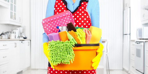 Maid hands with cleaning tools.