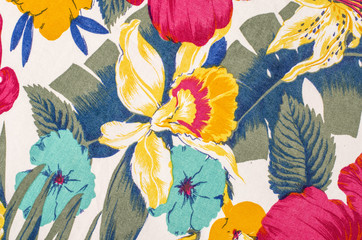 Floral pattern on white fabric. Colorful exotic flowers with green and blue leaves print as...