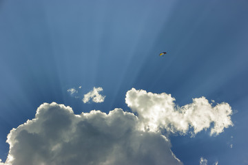 paraglider flying into god rays