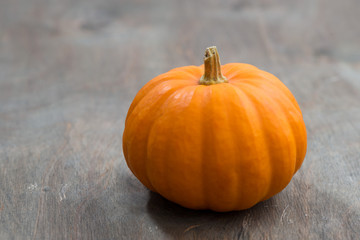 orange pumpkin on a wooden background, closeup, selective focus