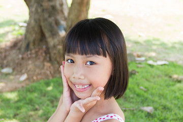 Happy little girl having fun and smiling at the park