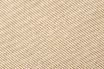 Striped brown and beige textile pattern as a background. Close up on diagonal stripes material texture fabric.