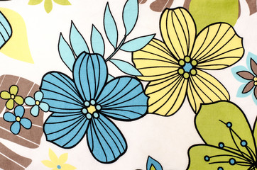 Floral pattern on white fabric. Colorful exotic blue and yellow flowers print as background.