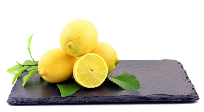 Fresh lemons on white ground, on stone board.
