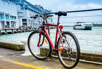 Fototapeta premium Red parked bicycle on the pier at harbor