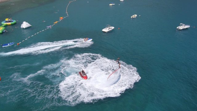 Aerial view on man enjoying water jet pack flyboard at the sea.
