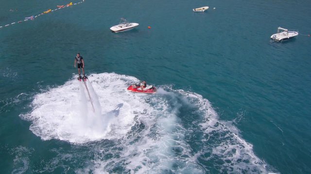 Aerial view on man enjoying water jet pack flyboard at the sea.
