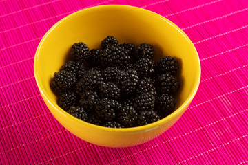 Fresh blackberries in a yellow bowl