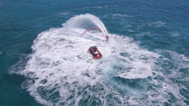 Aerial view on man enjoying water jet pack flyboard at the sea.
