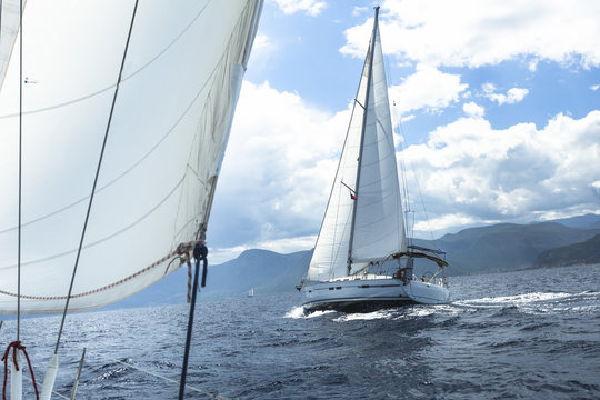 Sailing. Ship yachts with white sails in the open Sea. Luxury Lifestyle.