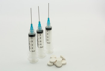 Five ml disposable plastic syringes blue needles white pills