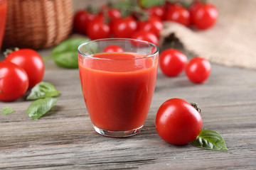 Glass of tomato juice with vegetables on wooden table close up