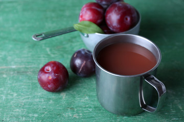 Delicious plum juice with fruits on wooden table close up