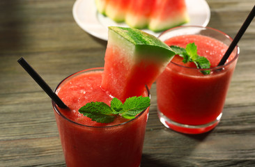 Glasses of watermelon juice on wooden table, closeup