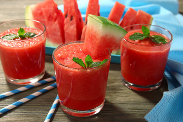 Glasses of watermelon juice on wooden table, closeup