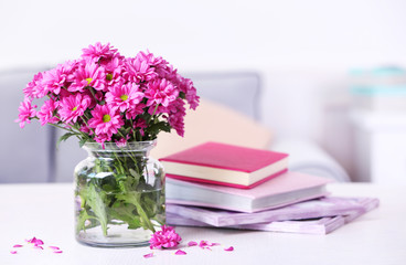 Beautiful flowers in vase on table in room