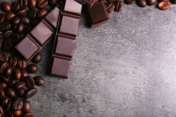 Dark chocolate pieces and coffee grains on dark gray background