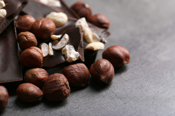 Black chocolate pieces and nuts on dark gray background