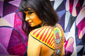 Bodypainting yellow Cleopatra, vivid, colorful woman, mysterious Egyptian queen model on  purple...
