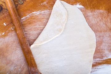 Laghman dough on an old wooden worn board with flour