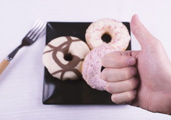 Donutos on a black plate with eating utensils