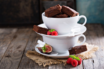 Brownies in stacked coffee cups with chocolate sauce