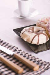 Donutos on a black plate with eating utensils