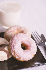 Donutos on a black plate with eating utensils