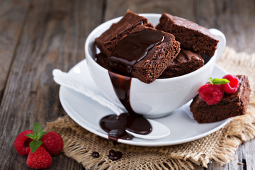 Brownies in stacked coffee cups with chocolate sauce