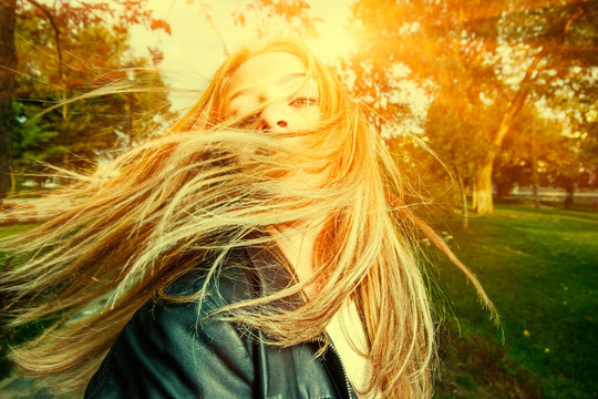 Young woman with wind swept hair backlit 