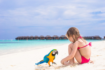 Cute big colorful parrot with adorable little girl on white