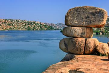 View of huge boulders on the bank of the lake, Hampi, Karnataka, India.