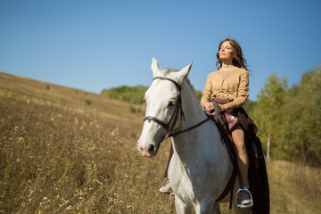 Beautiful girl riding a white horse