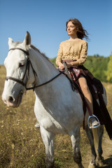 Obraz premium Beautiful girl riding a white horse