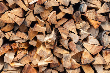 Background of dry chopped firewood logs in a pile