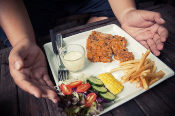 Fat Man Eating pork steak In a coffee shop