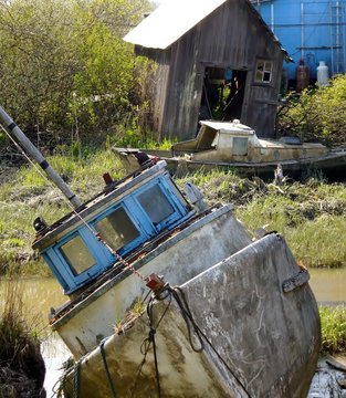 Old boat tipped over at Finn Slough, Fraser River, Richmond, British Columbia, Canada