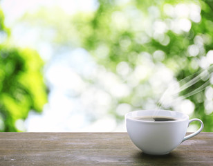 Cup of coffee on table on bright background