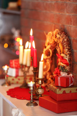 Christmas decorations and candles on mantelpiece