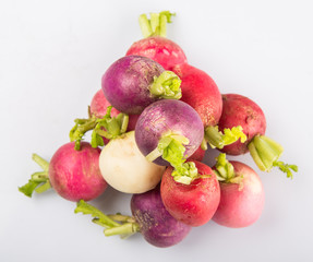 Pink, red, dark red, purple, and white radish vegetable over white background