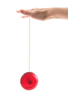 A hand holding a red yoyo as it goes up and down, isolated on white.