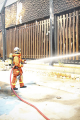 Firefighters prepare to attack a propane fire during a training exercise. Firefighters spray water to wildfire.