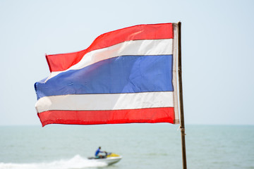 Thai flag on the beach with jetski in background