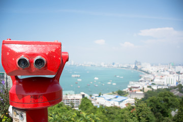 Coin-operated binoculars with pattaya beach in background