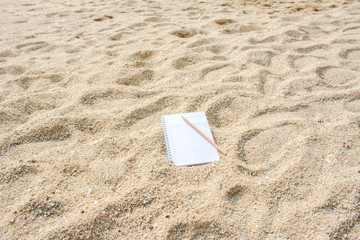 Blank note with pencil on the beach